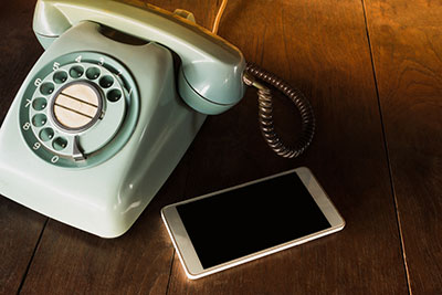 old-style landline phone and modern mocile phone