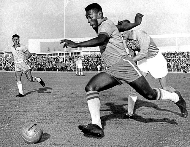 Pelé dribbling past a defender